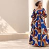 Femme portant une longue robe en wax bleue, blanche et orangée